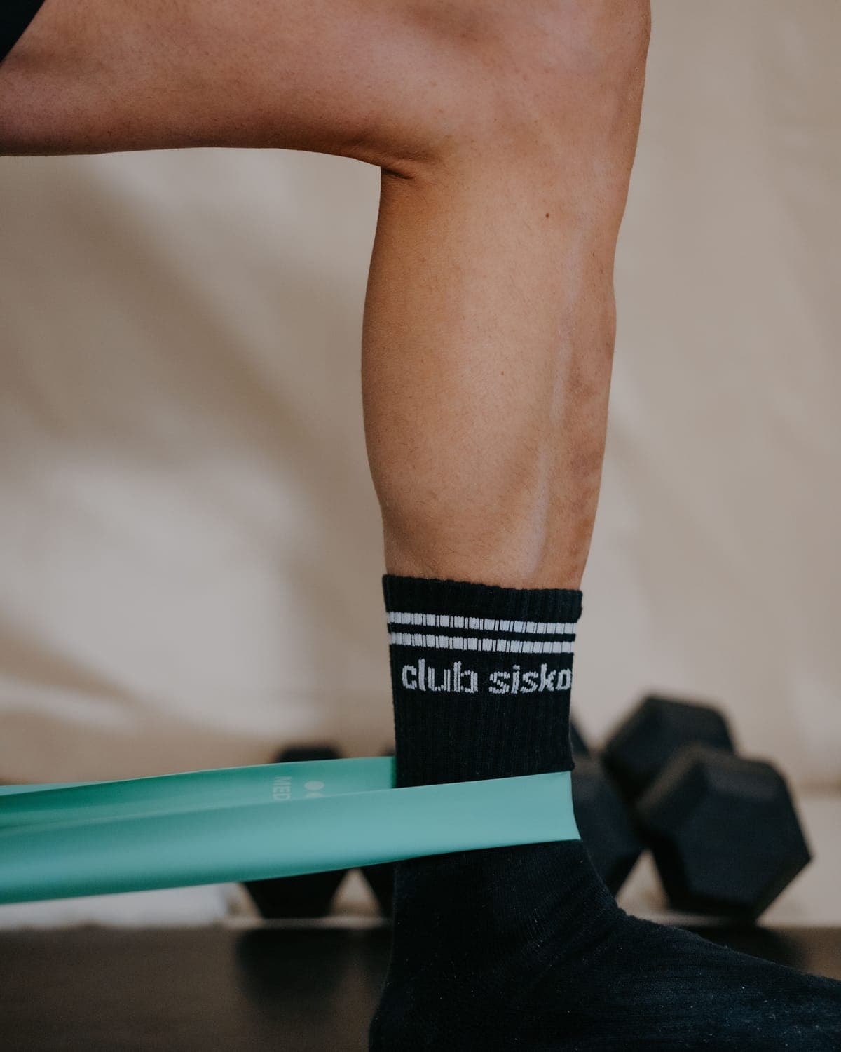 Élastique de résistance à la cheville, chaussette Club Sisko et haltères au sol, séance de bootcamp