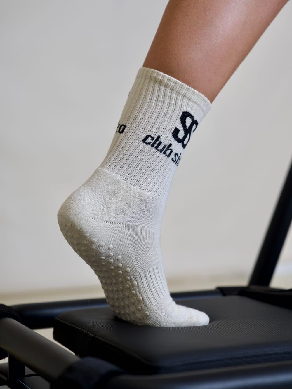 Chaussette antidérapante au monogramme Club Sisko posée sur le chariot d'un Microformer